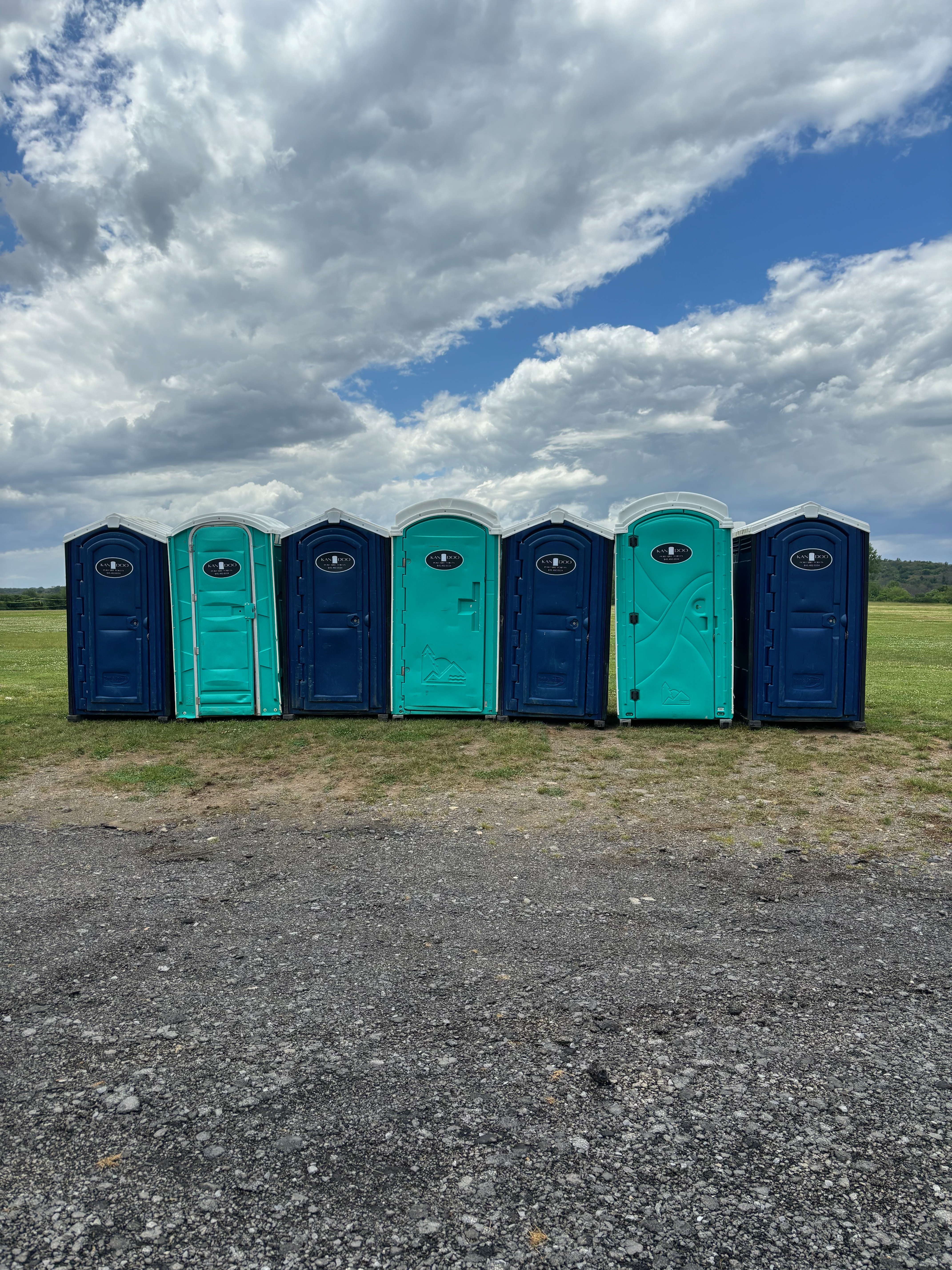 Kan Doo Portable Toilets providing RV and camper pumping service in Hudson Valley, NY., Portable toilet set near fenced renovation area beside active delivery path